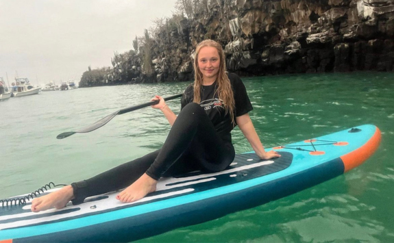 Mollie paddleboarding in the sea on the Galapagos islands